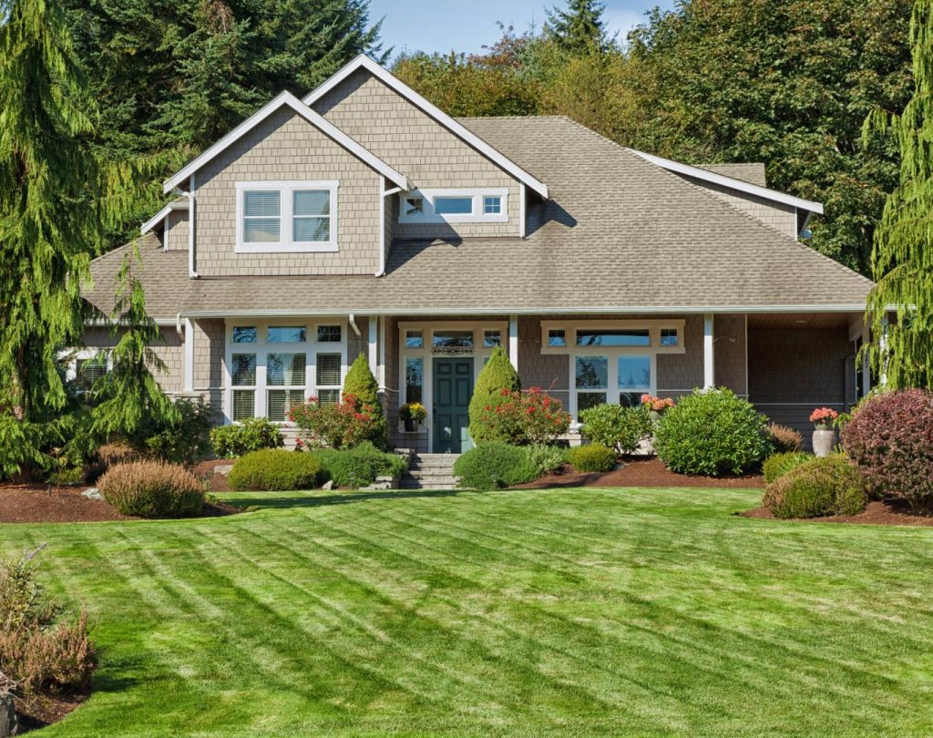 Front yard landscaping in Shawnee County, KS with stonework and shrubs