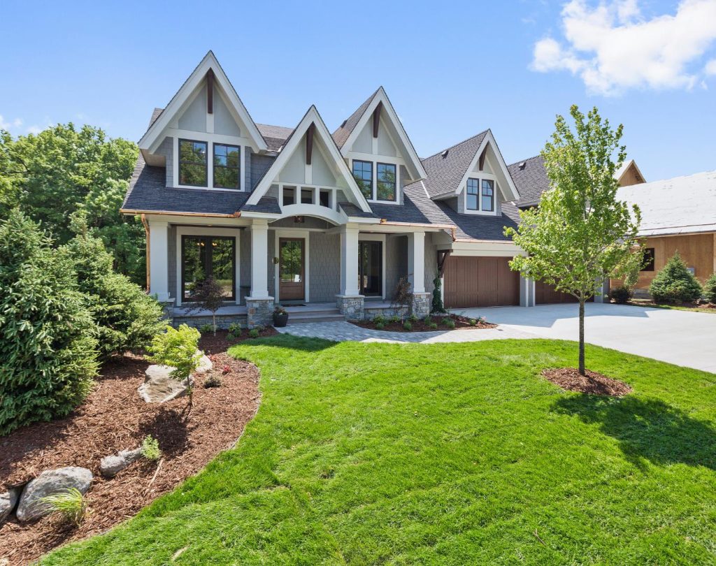 Landscaping near me in Olathe, KS featuring sod, shrubs, and flower beds